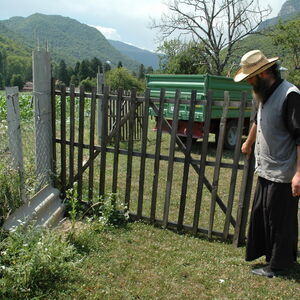 Monk opening a gate for the harvestor to enter
